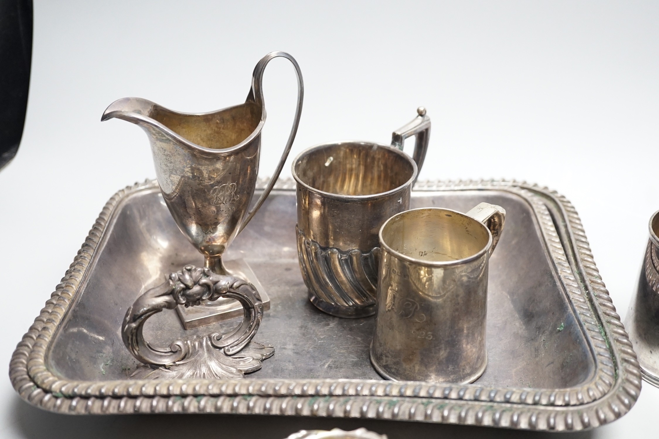 A small collection of English silver to include a pair of Victorian cauldron salts, two small beakers, a cream jug with presentation script, a George IV silver mustard pot with hinged cover, London, 1823 and a boxed chri